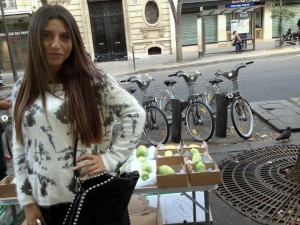 A young woman outside of a synagogue in Paris sells lulov and estrog for Sukkot Blessings.